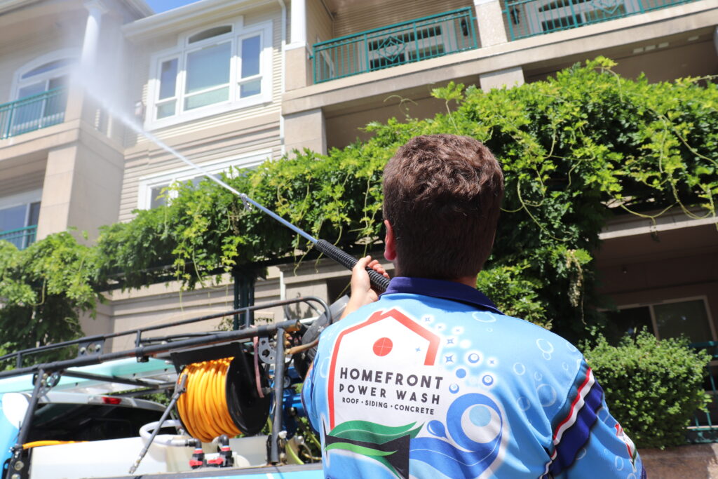 Dillon Bissell, owner of Homefront Power Wash spraying an apartment complex in Bellevue, WA