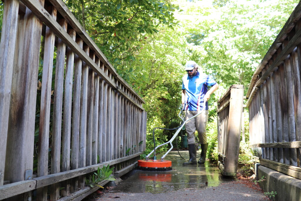 Homefront Power Wash Specialist cleaning the pavement at an apartment complex on the Eastside