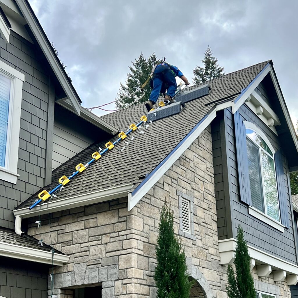 Dillon Bissell, owner of Homefront Power Wash, installing lights on a roof in Bellevue, WA