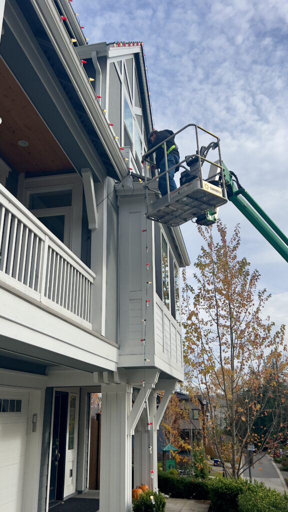 Homefront Holiday Lights on a crane installing holiday lights on an apartment complex