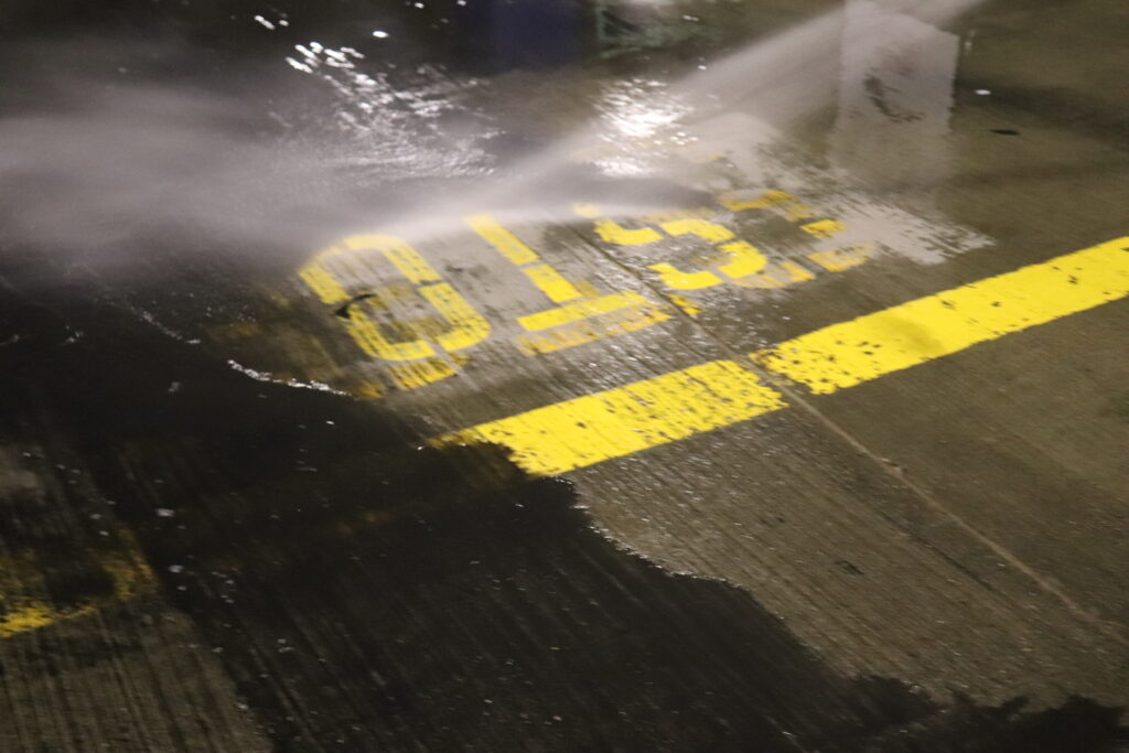 Homefront Power Wash cleaning the parking lot floor and showing a the dirt accumulation while cleaning the parking garage at Pike Place Market in Seattle, WA